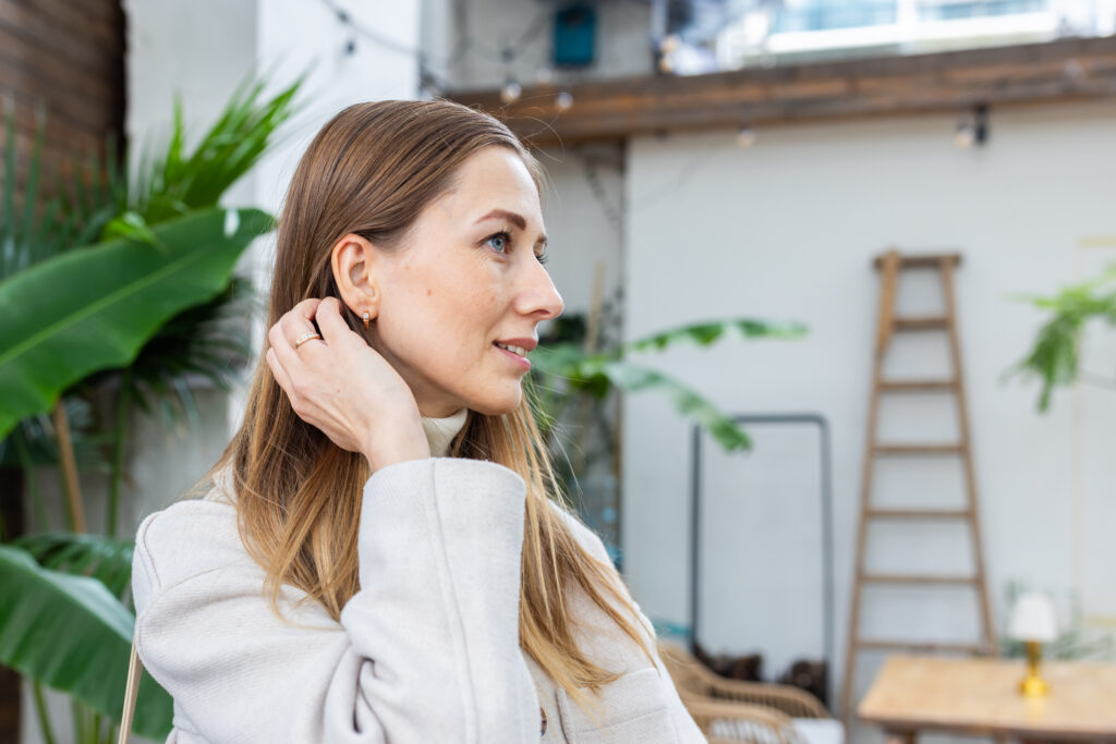 Frau mit Hörgerät lächelt entspannt – Hörgeräte bei Tinnitus können das Hören und die Lebensqualität verbessern.
