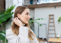 Frau mit Hörgerät lächelt entspannt – Hörgeräte bei Tinnitus können das Hören und die Lebensqualität verbessern.