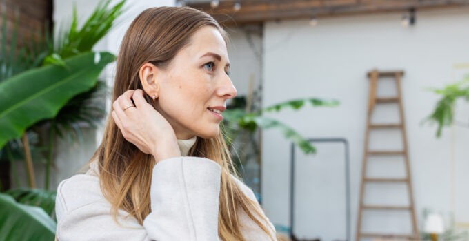 Frau mit Hörgerät lächelt entspannt – Hörgeräte bei Tinnitus können das Hören und die Lebensqualität verbessern.